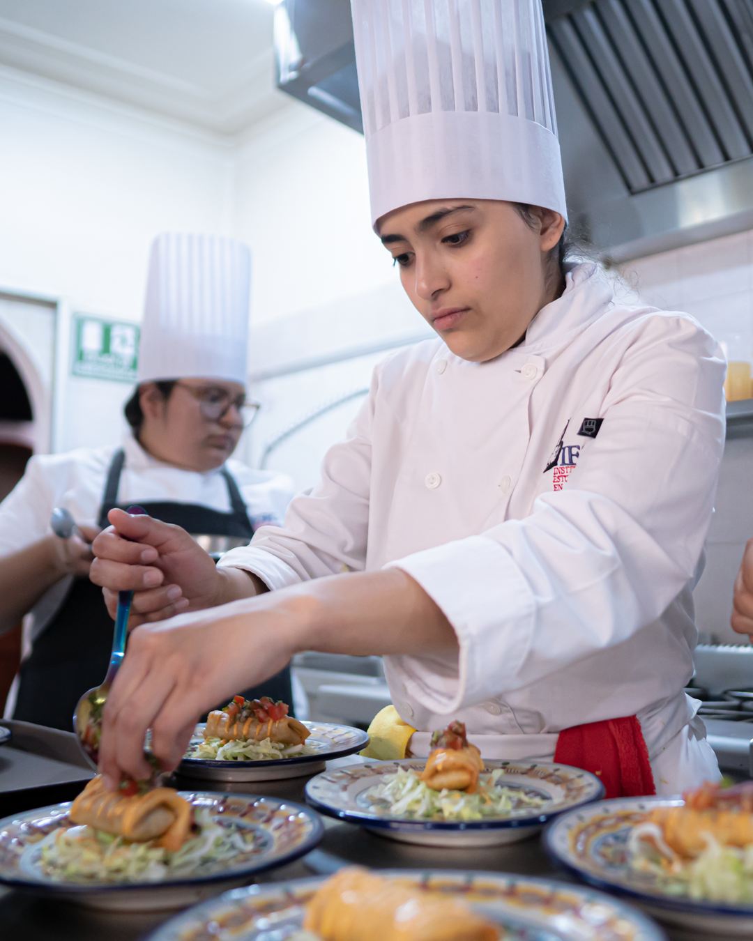 Chef preparando platillos en cocina profesional